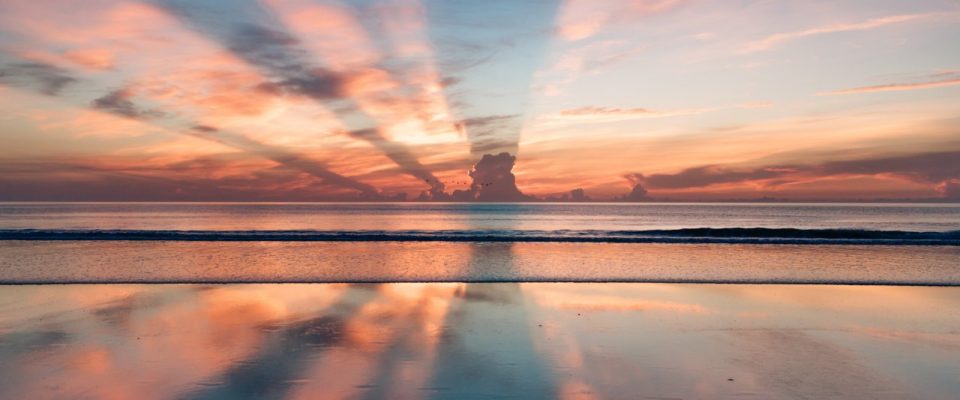 Sun Setting Behind Clouds with Water Reflection